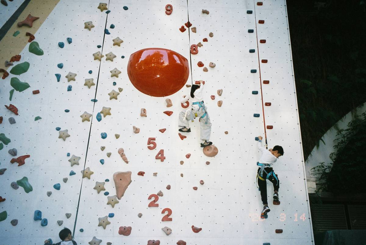 Side-by-side comparison: child's bare hand vs. hand wearing kids grip climbing gloves on climbing holds showing reduced slippage and better finger placement